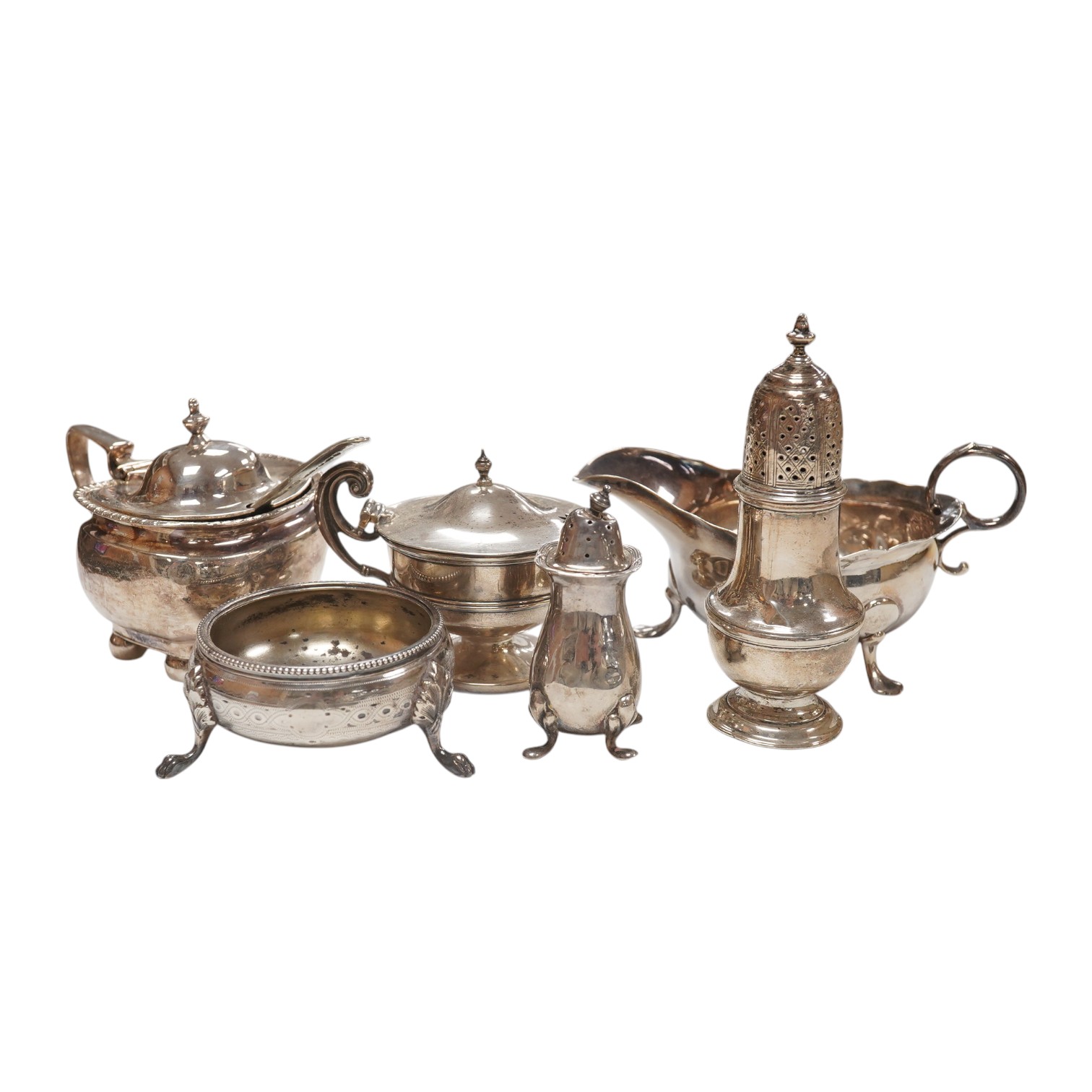 A George II provincial silver sauceboat, John Langlands I, Newcastle, 1751, a.f. and five assorted silver condiments including a George II silver pepperette, London, 1750, 11.2cm. Condition - poor to fair